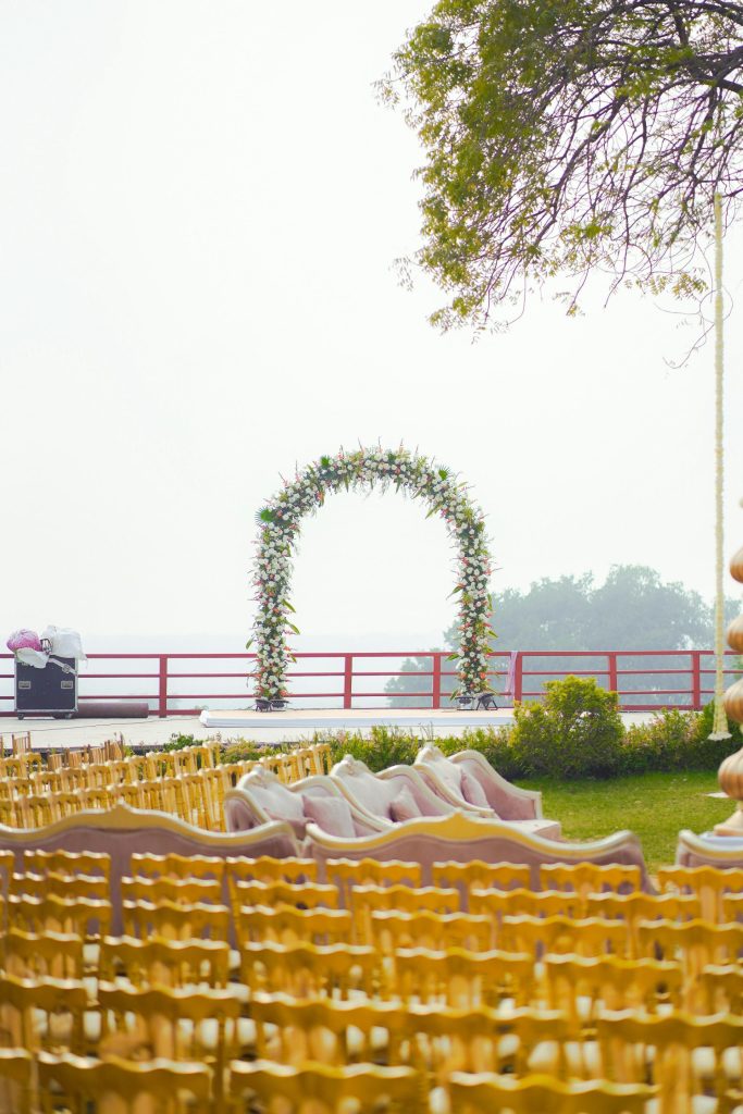 A wedding ceremony setup with floral arch and seating.